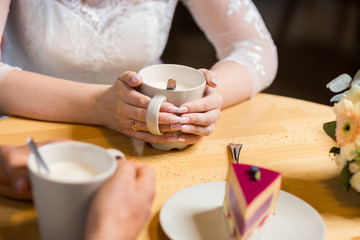 girl drinks coffee with fruit cakes at a cafe