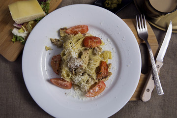 Pasta with pesto sauce, chicken,  tomato and cheese