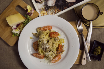 Pasta with pesto sauce, chicken,  tomato and cheese