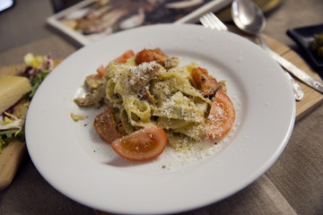 Pasta with pesto sauce, chicken,  tomato and cheese