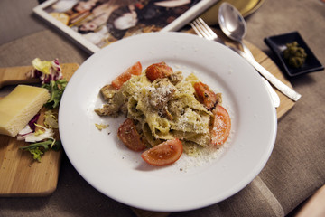 Pasta with pesto sauce, chicken,  tomato and cheese