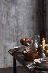 Rustic table setting with pumpkin soup and pumpkins