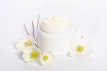 Obraz na płótnie Canvas Cute flowers and a jar of natural body cream isolated on white background
