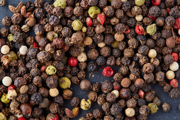 Mix of grind black pepper and black, white, red and yellow peppercorn. Selective focus.