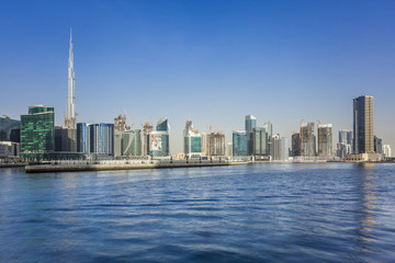 Panoramic view of construction at the Business Bay and downtown area of Dubai, yachts and boats sailing on Dubai creek.
