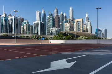 Skyscrapers in Dubai Marina, empty car park, metro station. Dubai, UAE.