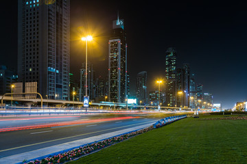 Car traffic on Sheikh Zayed road at night in downtown, skyscrapers with night illumination. Dubai, United Arab Emirates
