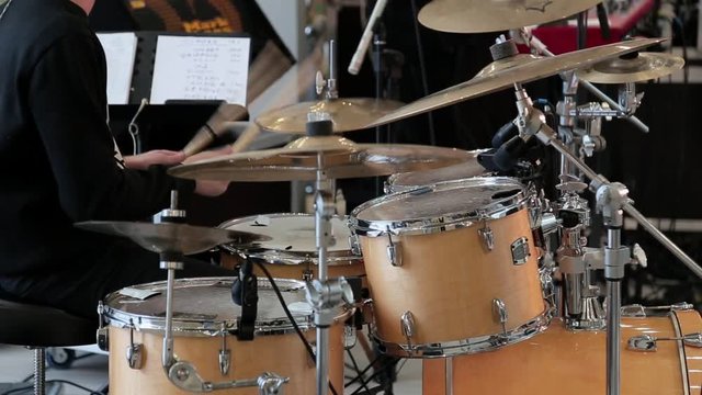the man plays on the drum set