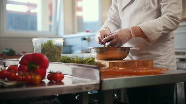 Chef preparing a salad in the kitchen of the restaurant