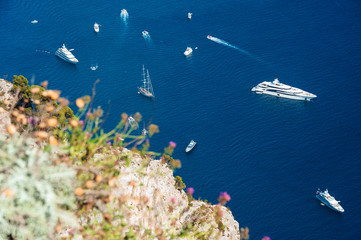 Aerial shot of beautiful blue lagoon at hot summer day with boats sailing around. Top view of people are swimming around the boats.