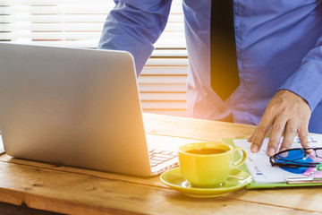 Business man analyzing investment charts with laptop computer and calculator on office desk table.Close up.Financial Report Revenue Statistical Accounting Concept.