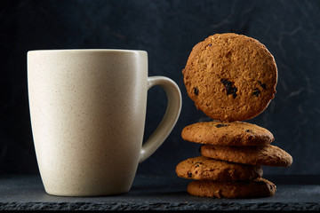 cup of tea and cookies isolated on a dark background, close-up