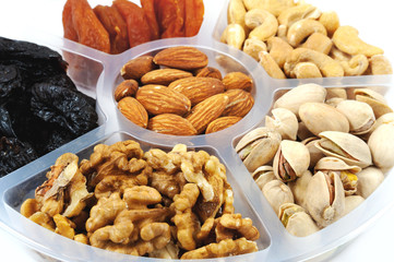 Mixture of fruits and nuts on a tray.  Isolated on white.
