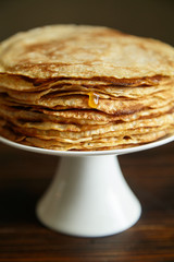 Crepes cake with orange jam and honey on white cake stand with text space. Pancake breakfast concept