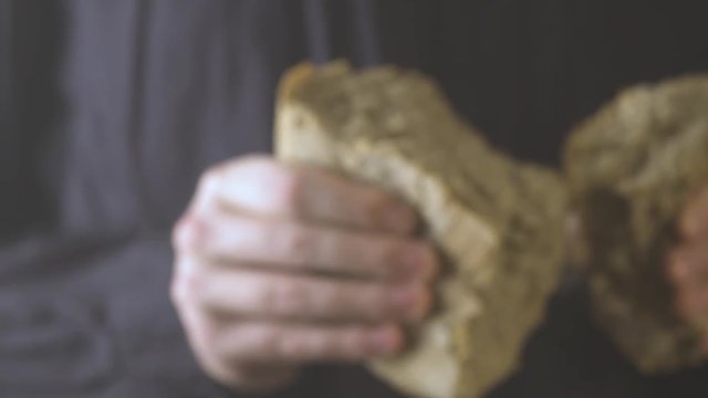 Baker hands breaking homemade bread. Close up view.