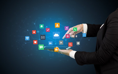 Hand holding tablet and application icons above