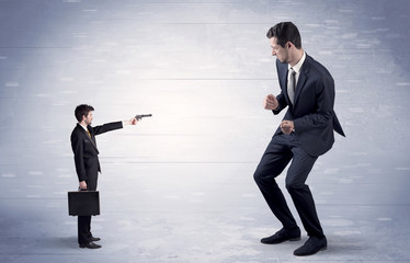 Fototapeta premium Small businessman shooting giant businessman