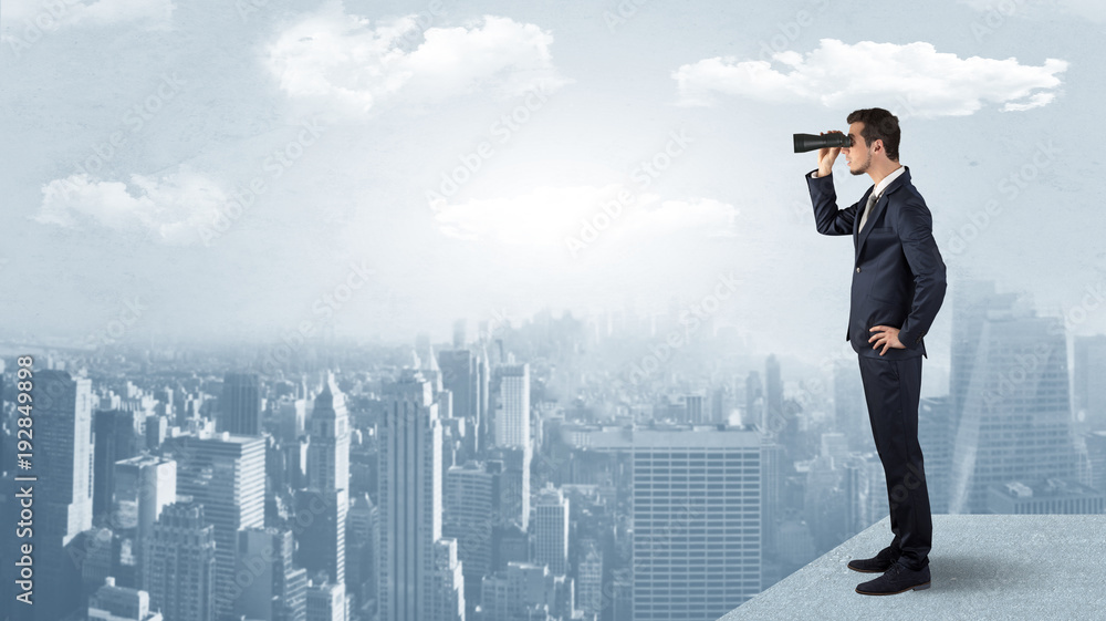 Wall mural man looking forward from the top of a skyscraper