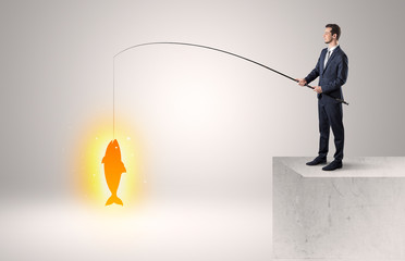 Businessman fishing golden fish concept
