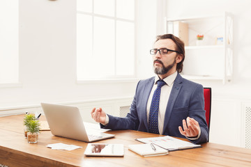 Fototapeta premium Relaxed businessman meditating at office