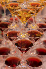 Pyramid of glasses for beverages, wine, champagne, red and yellow colors, festive mood celebration