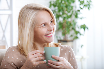 Portrait of happy brunette with mug in hands
