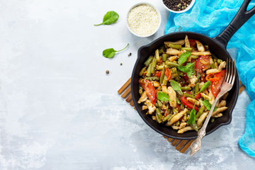 Vitamin lunch with chicken, green beans, arugula, tomatoes and vinaigrette sauce, stone or slate background. Proper nutrition. Healthy lifestyle. Top view.