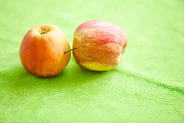 Delicious fresh yellow-red apples on a green cloth.