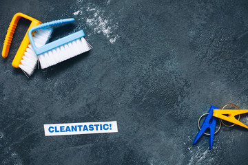 Cleaning house or office concept. Blue and yellow cleaning brushes, clothes pegs, Cleantastic...
