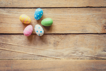 Colorful easter egg on wood background with space.