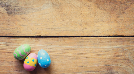 Colorful easter egg on wood background with space.