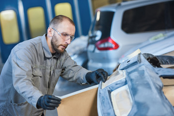 auto repairman worker with protecting paper in garage workshop