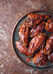 Delicious hot homemade bbq chicken wings with different spices in plate top view