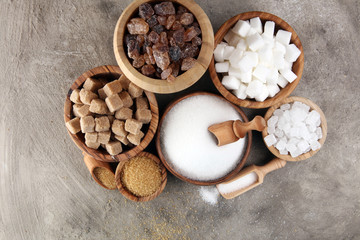 Various types of sugar, brown sugar and white on table