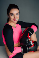 Close up portrait of a young sportswoman in boxing gloves. Pretty female brunete boxer. Healthy lifestyle concept. Girl fighter.