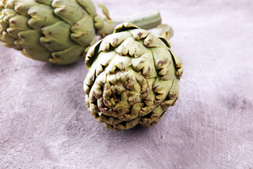 Obraz premium artichokes on grey background. fresh organic artichoke flower.