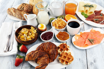 breakfast on table with waffles, croissants, coffe and juice