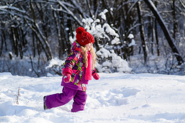 Fototapeta na wymiar Little cute girl runs through snow