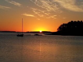 sunrise in Maine with clouds and oats at anchor