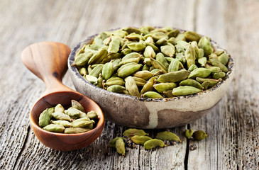 Cardamom on wooden background - obrazy, fototapety, plakaty