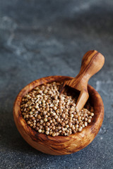 Coriander seeds in a wooden bowl, selective focus, copy space