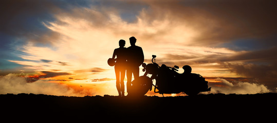 Obraz premium młoda zaręczona para wysiąść z motocykla, by podziwiać zachód słońca