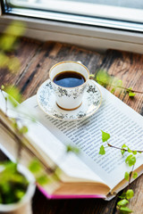 open book, coffee mug by the window, the concept of dreams and thoughtfulness