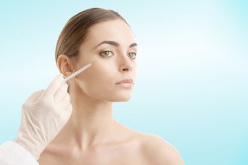 Young woman receiving cosmetic treatment with syringe injection