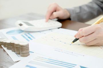 Close up woman using calculator on paper graph data