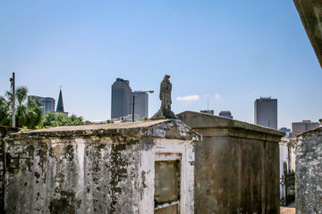 Fototapeta na wymiar Contrast: One of New Orleans' oldest cemeterys sits with modern New Orleans in the background, April 2012.