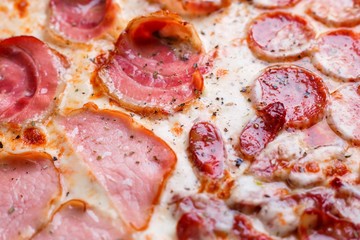 Pizza texture. Close up of pizza with bacon, salami,ham and pepperoni, food background