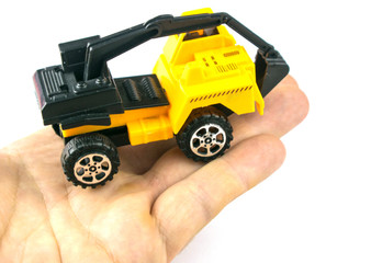 Fototapeta premium A toy excavator on a hand on a white background. Isolated.