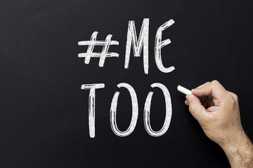 hand drawing Me Too hashtag on blackboard. Symbol of sexual harassment against women.