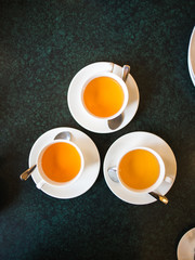 Obraz na płótnie Canvas top view of three cups with fresh herbal tea